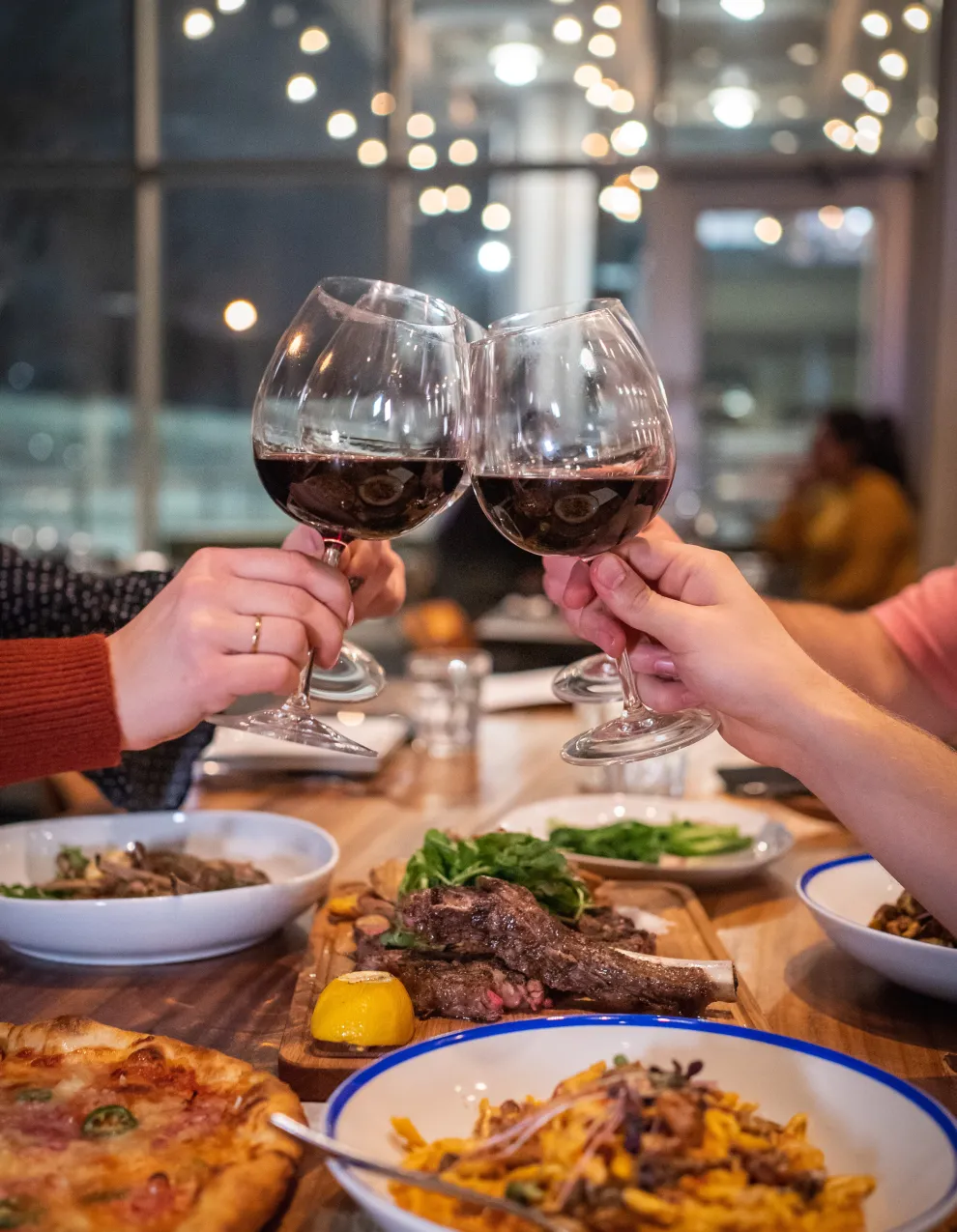 People enjoying glasses of wine around restaurant table