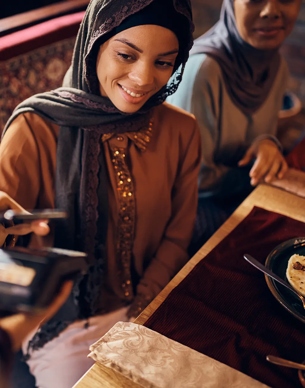A woman paying for her meal at a restaurant.